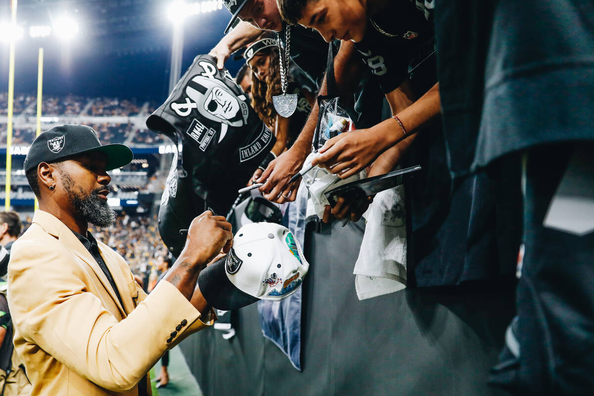 Former Raiders defensive back Charles Woodson signs autographs for fans before a Raiders game a ...