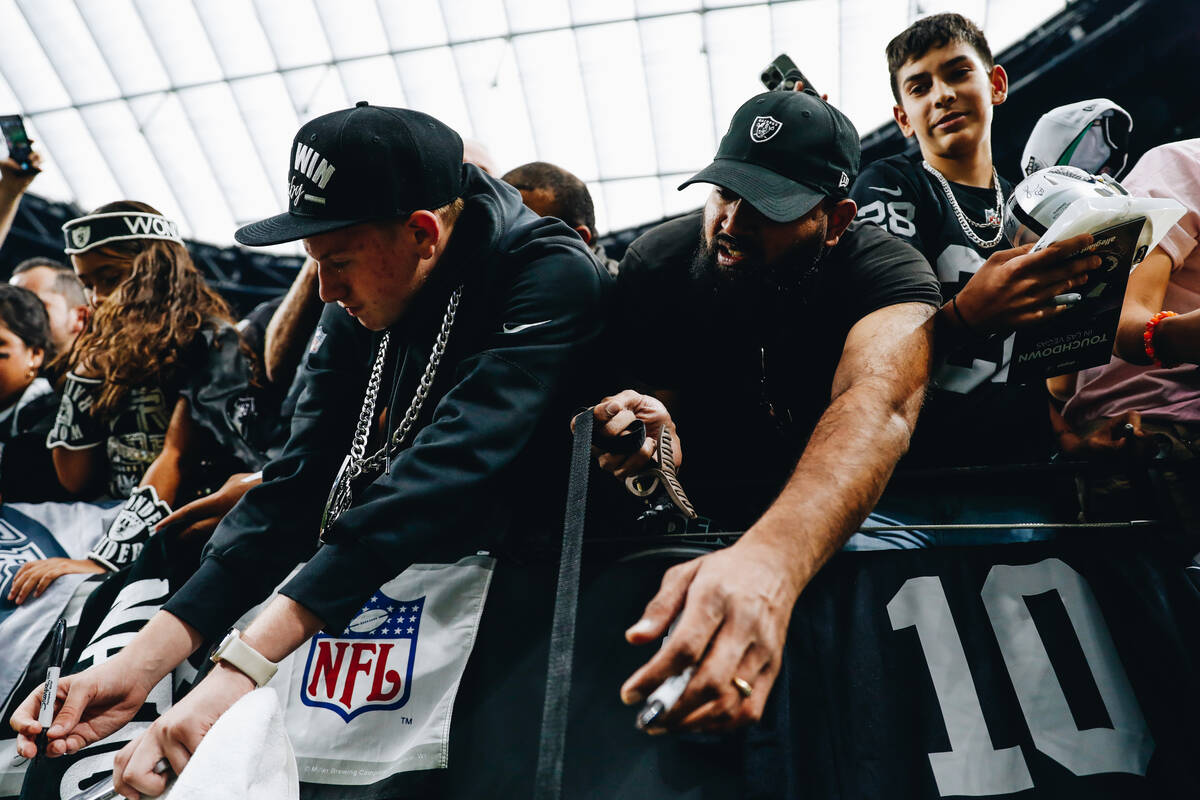 Raiders fans beg former Raiders defensive back Charles Woodson for an autograph before a game a ...