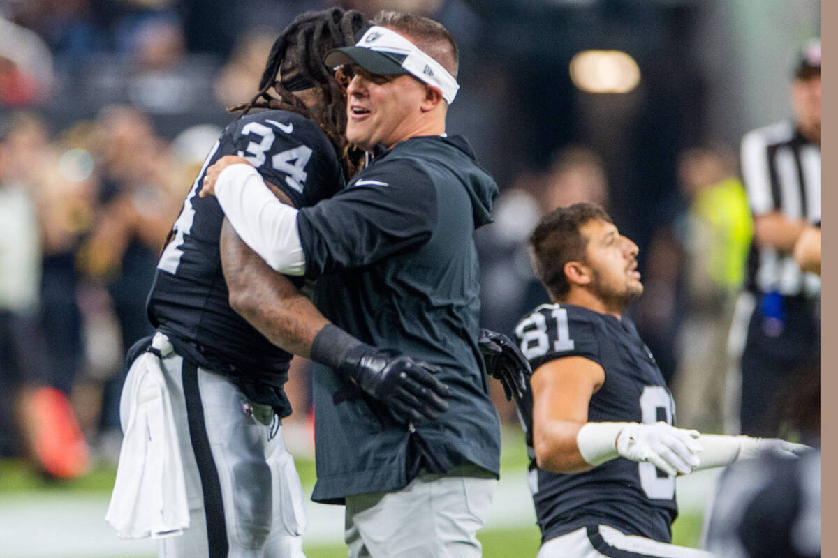 Raiders Head Coach Josh McDaniels hugs running back Brandon Bolden (34) during warm ups before ...