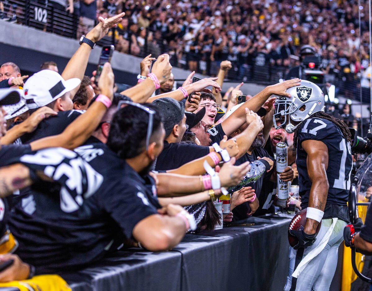 Raiders wide receiver Davante Adams (17) celebrates his touchdown with the fans during the firs ...