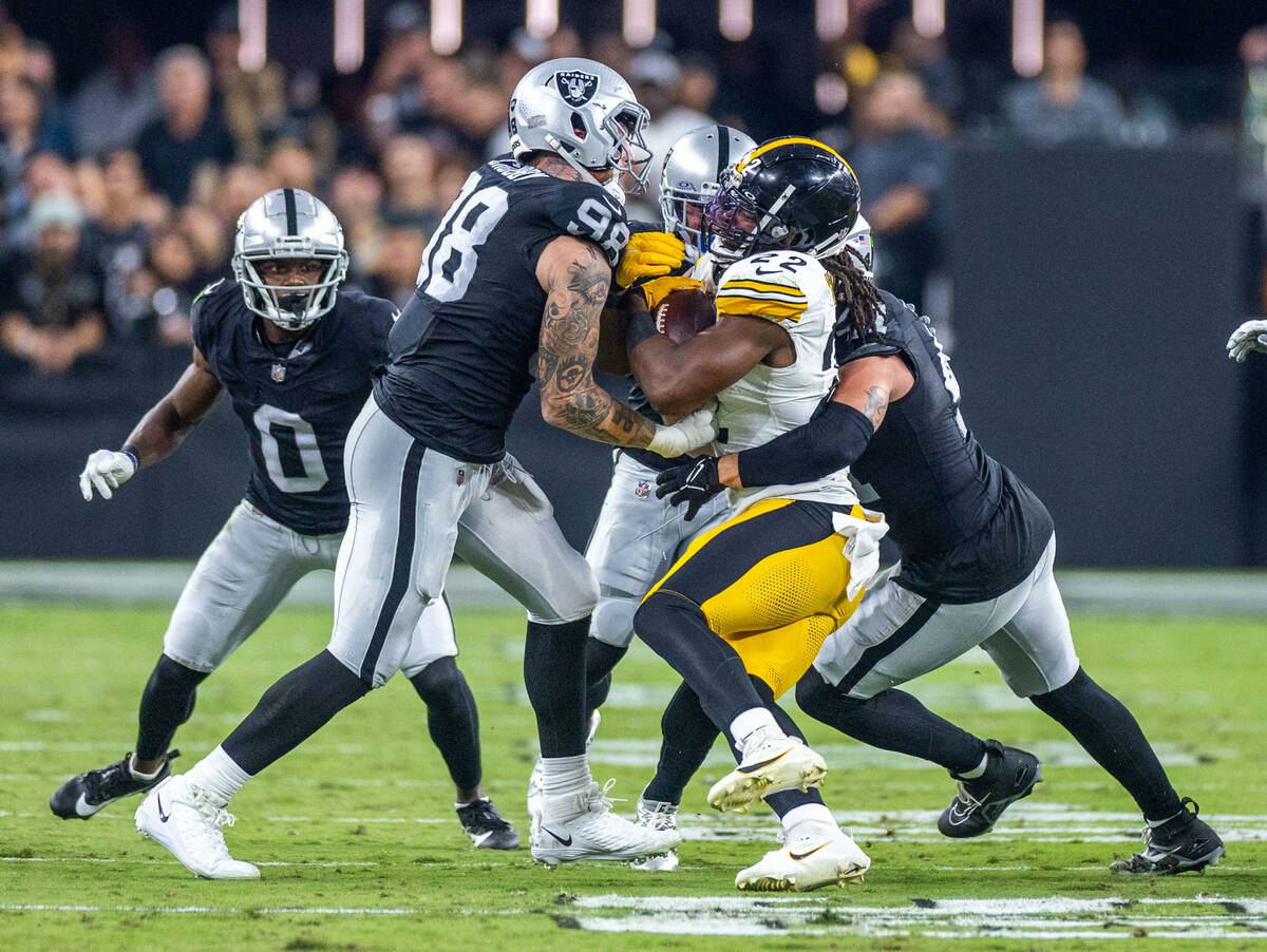 Raiders defensive end Maxx Crosby (98) and teammates tackle Pittsburgh Steelers running back Na ...