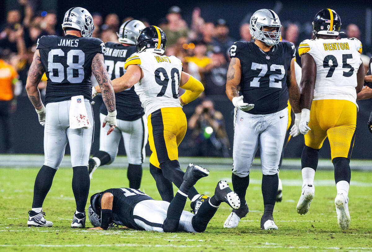 Raiders quarterback Jimmy Garoppolo (10) lies on the turf in pain after being bent back by Pitt ...