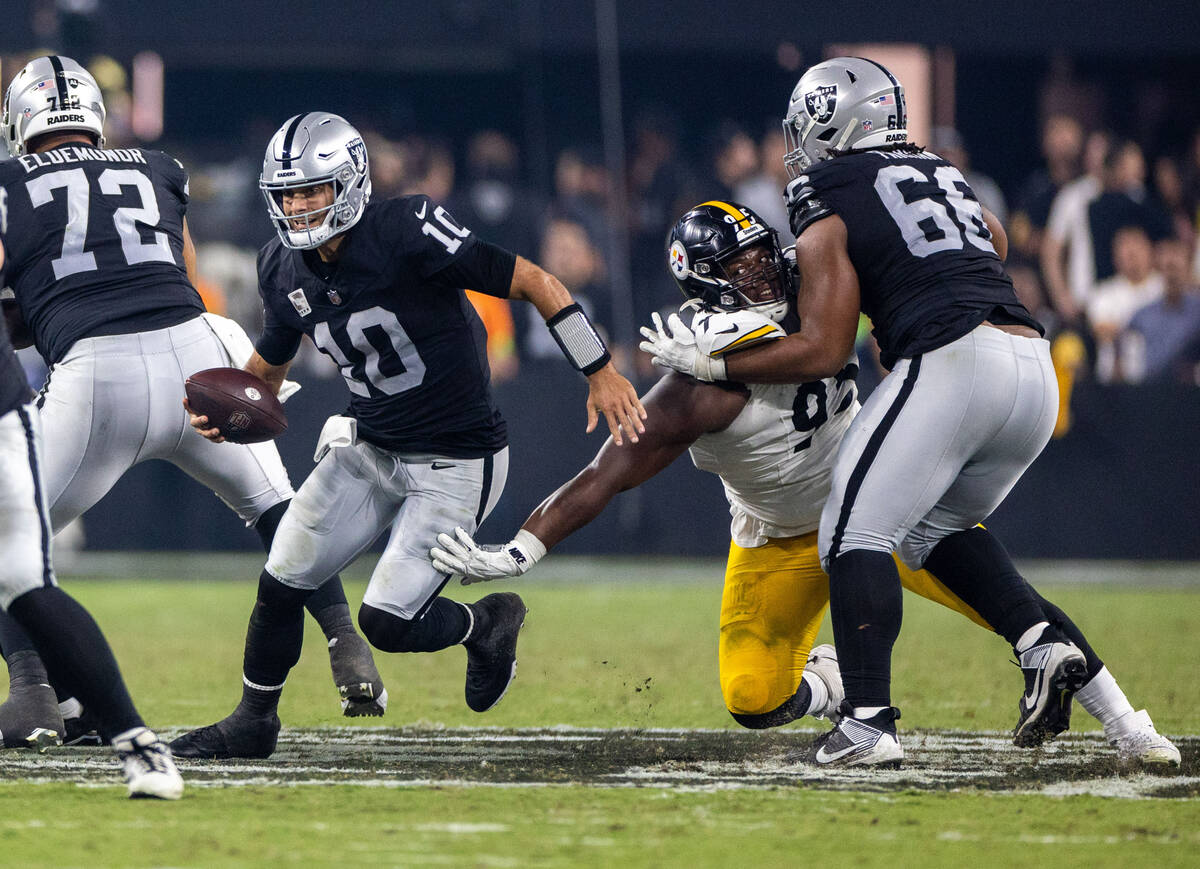 Raiders quarterback Jimmy Garoppolo (10) attempts to scramble away from Pittsburgh Steelers def ...