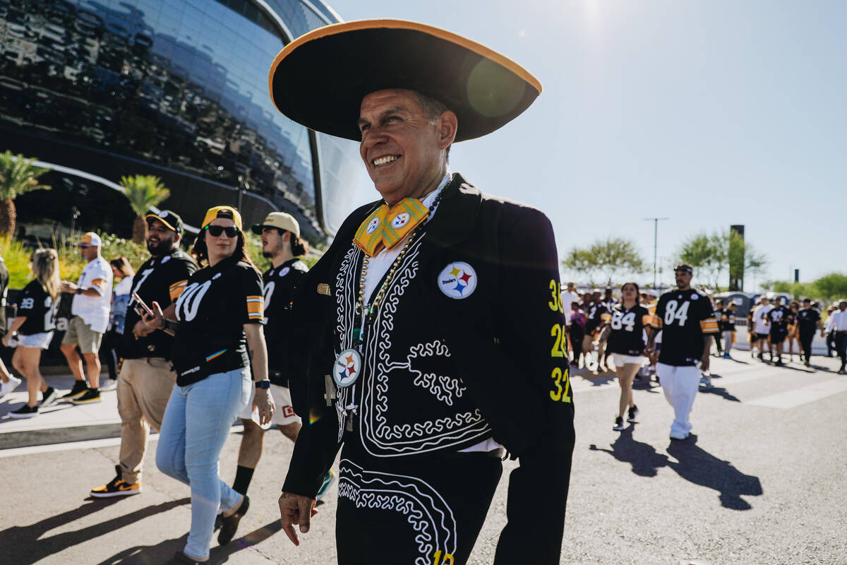 Pittsburgh Steelers fan Jose Farias walks into Allegiant Stadium before an NFL football game ag ...