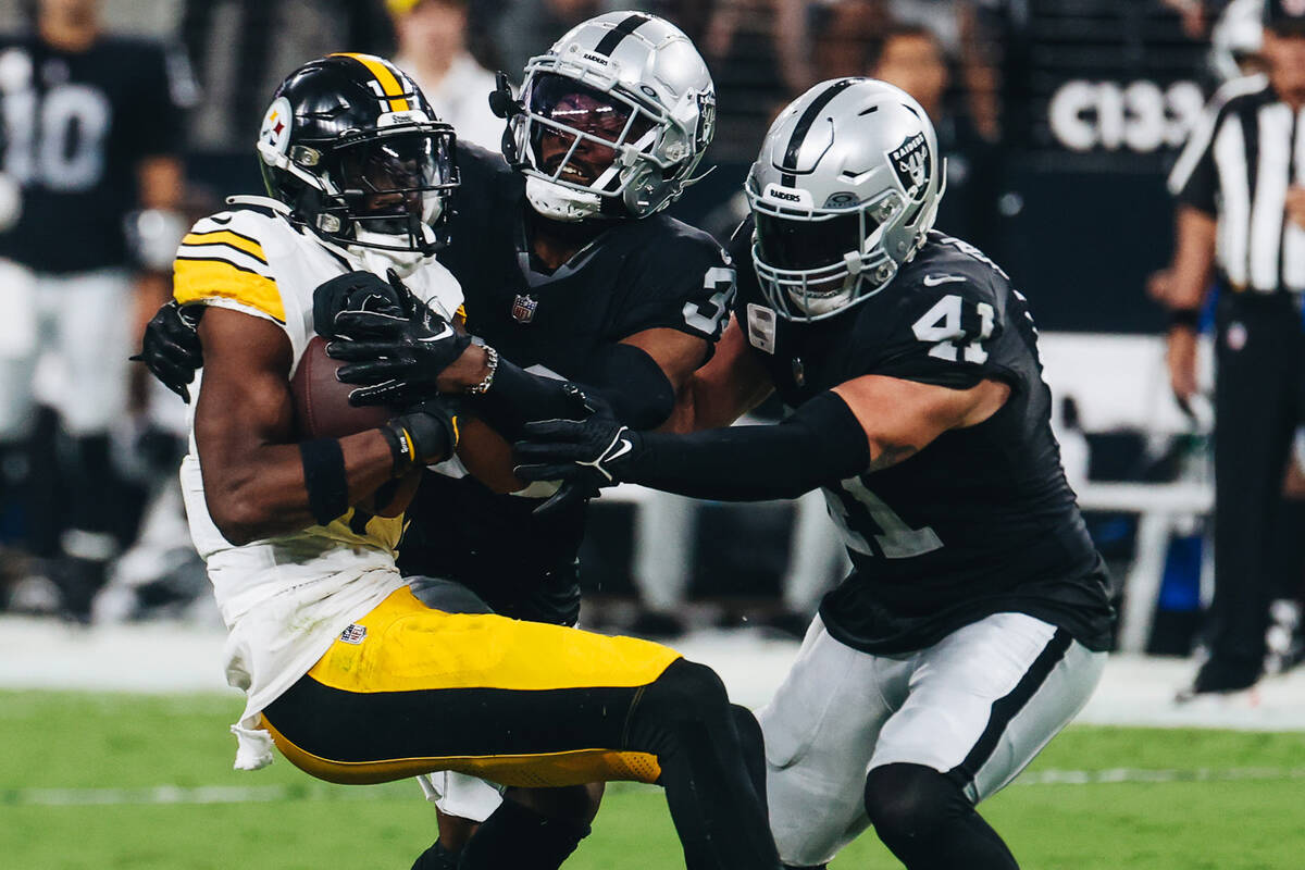 Pittsburgh Steelers wide receiver George Pickens (14) holds onto the ball as Raiders defensive ...