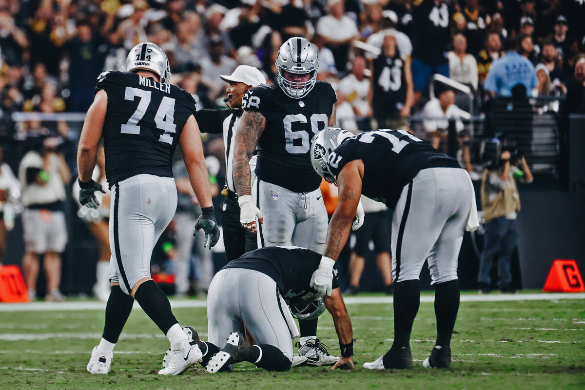 Raiders quarterback Jimmy Garoppolo (10) is comforted by teammate Jermaine Eluemunor (72) after ...