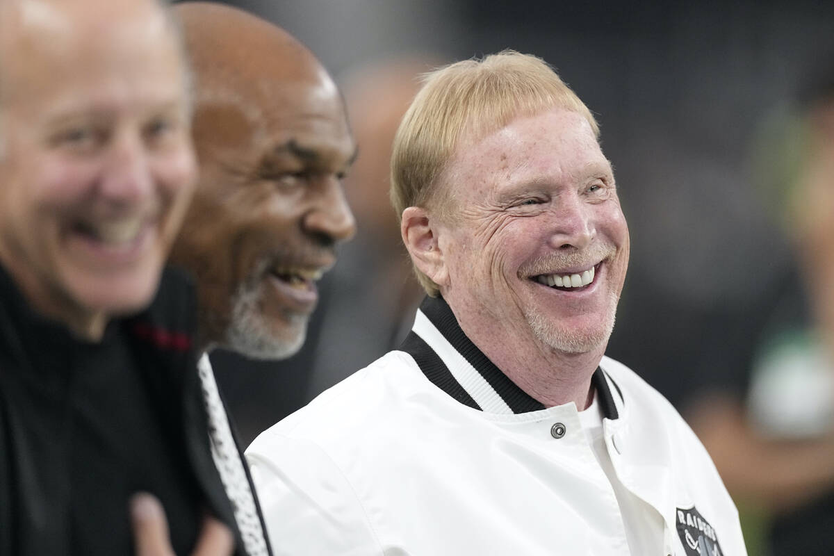 Las Vegas Raiders owner Mark Davis, right, smiles on the field next to former professional boxe ...