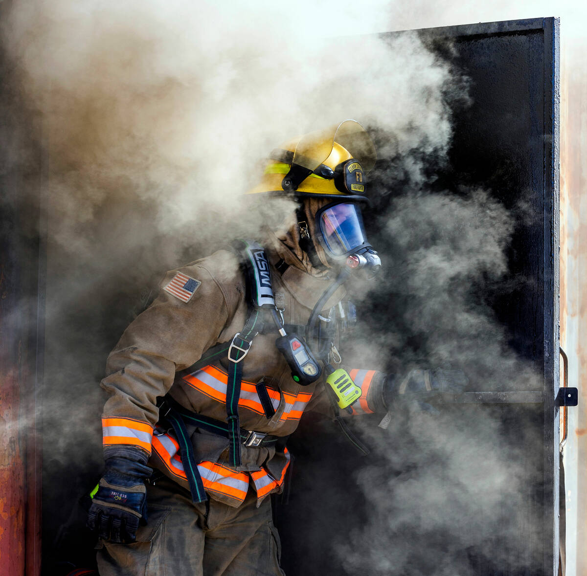 Clark County Fire Department Firefighter Instructor Matt Lemieux follows recruits from a smoky ...