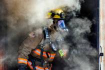 Clark County Fire Department Firefighter Instructor Matt Lemieux follows recruits from a smoky ...
