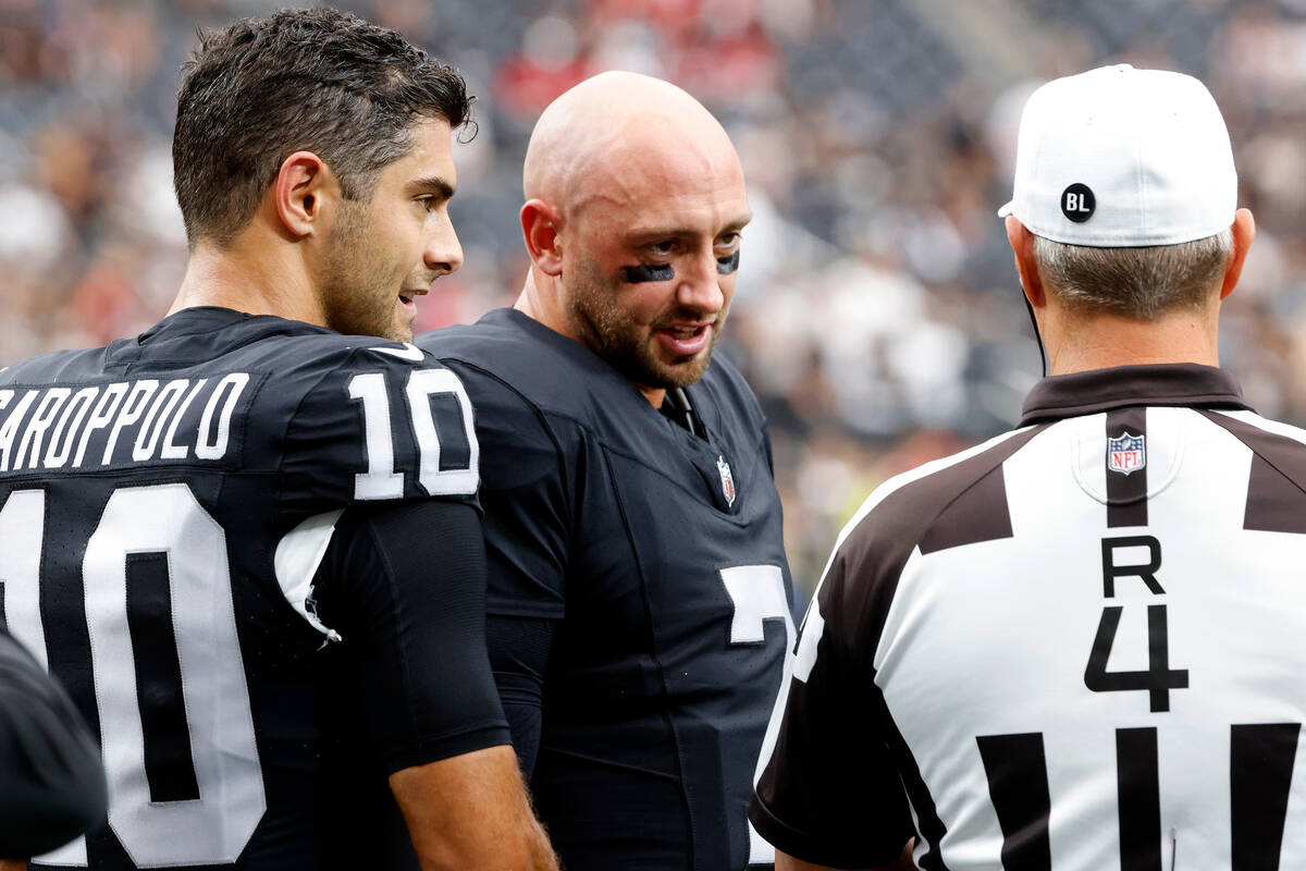 Raiders quarterbacks Jimmy Garoppolo (10) and Brian Hoyer (7) chat with referee Craig Wrolstad ...