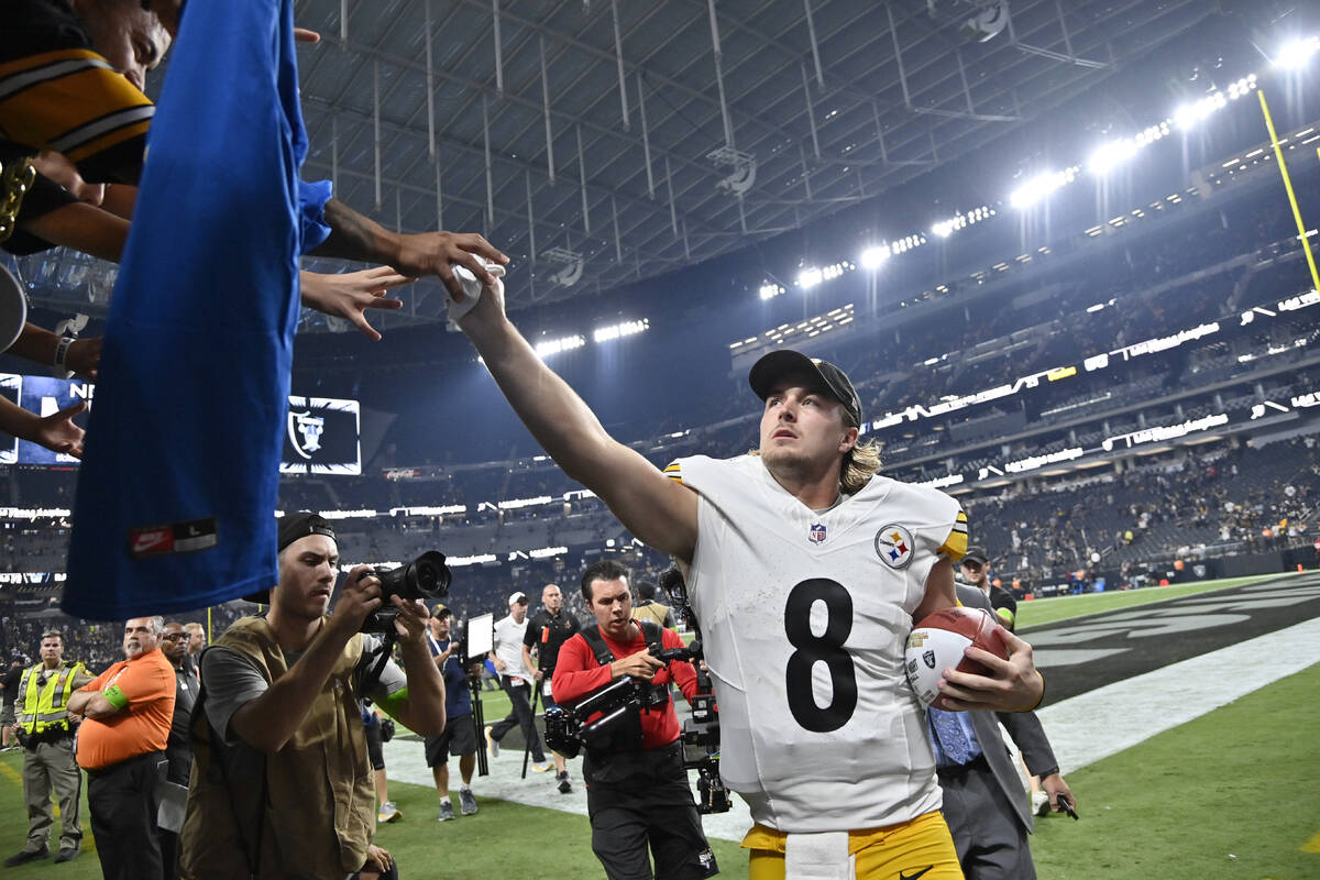 Pittsburgh Steelers quarterback Kenny Pickett gives his glove to a fan in the stands after a wi ...