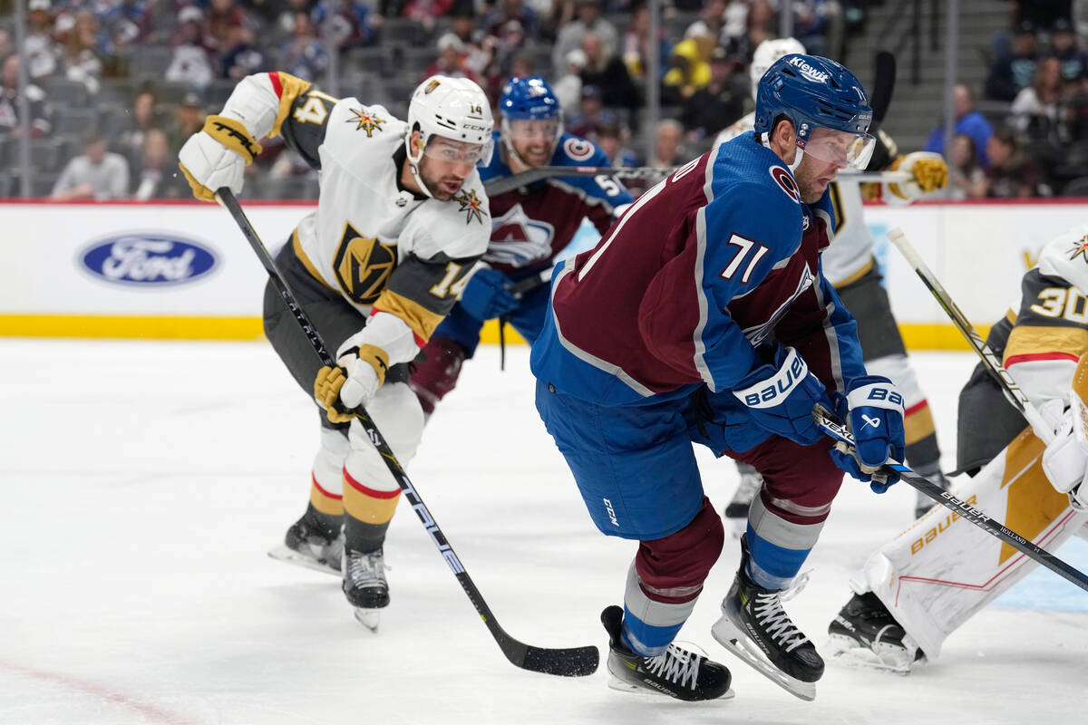 Colorado Avalanche center Peter Holland, right, pursues the puck with Vegas Golden Knights defe ...