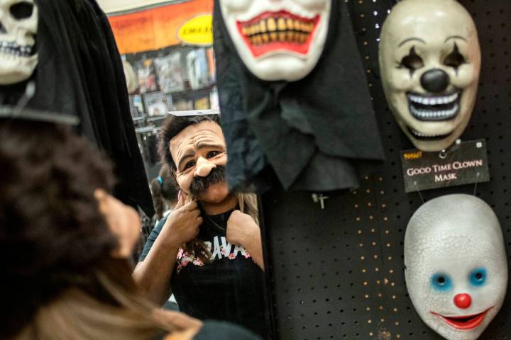 Laura Silva of St. George, Utah tries on a mask for her upcoming Halloween costume on Wednesday ...