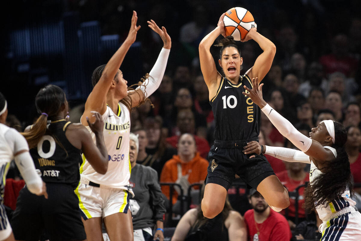 Las Vegas Aces guard Kelsey Plum (10) jumps to pass while guarded by Dallas Wings forward Satou ...