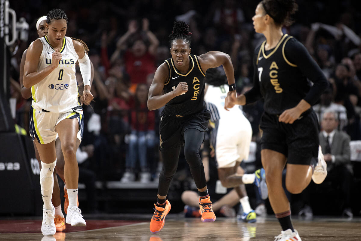 Las Vegas Aces guard Chelsea Gray, center, runs up the court after scoring next to Dallas Wings ...