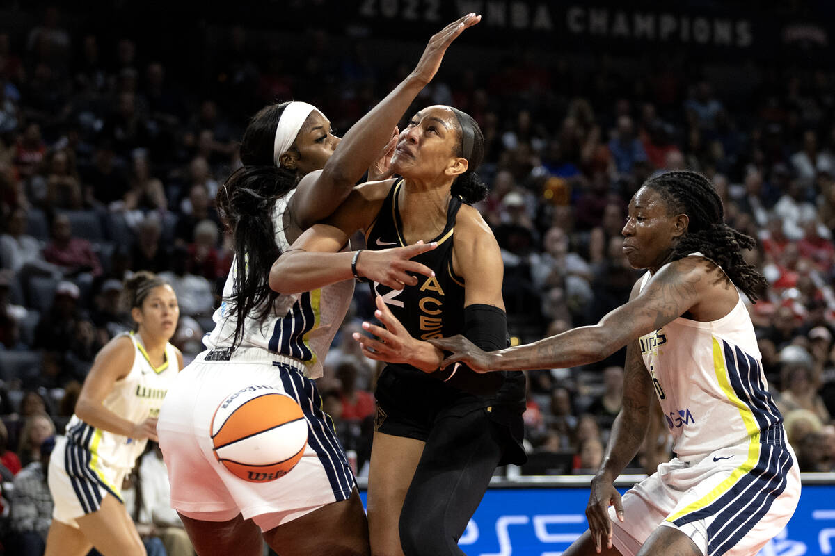 Las Vegas Aces forward A'ja Wilson (22) is fouled at the hoop by Dallas Wings forward Natasha H ...