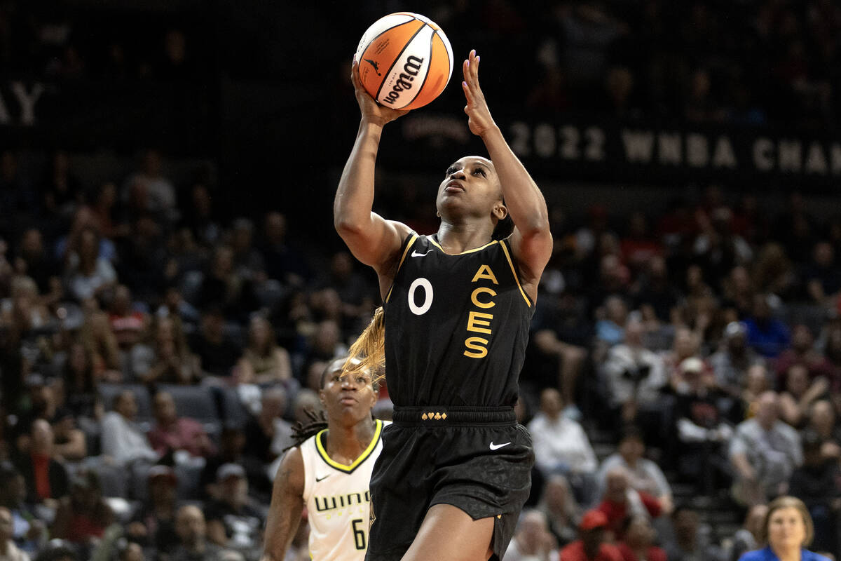 Las Vegas Aces guard Jackie Young (0) shoots while Dallas Wings forward Natasha Howard (6) look ...