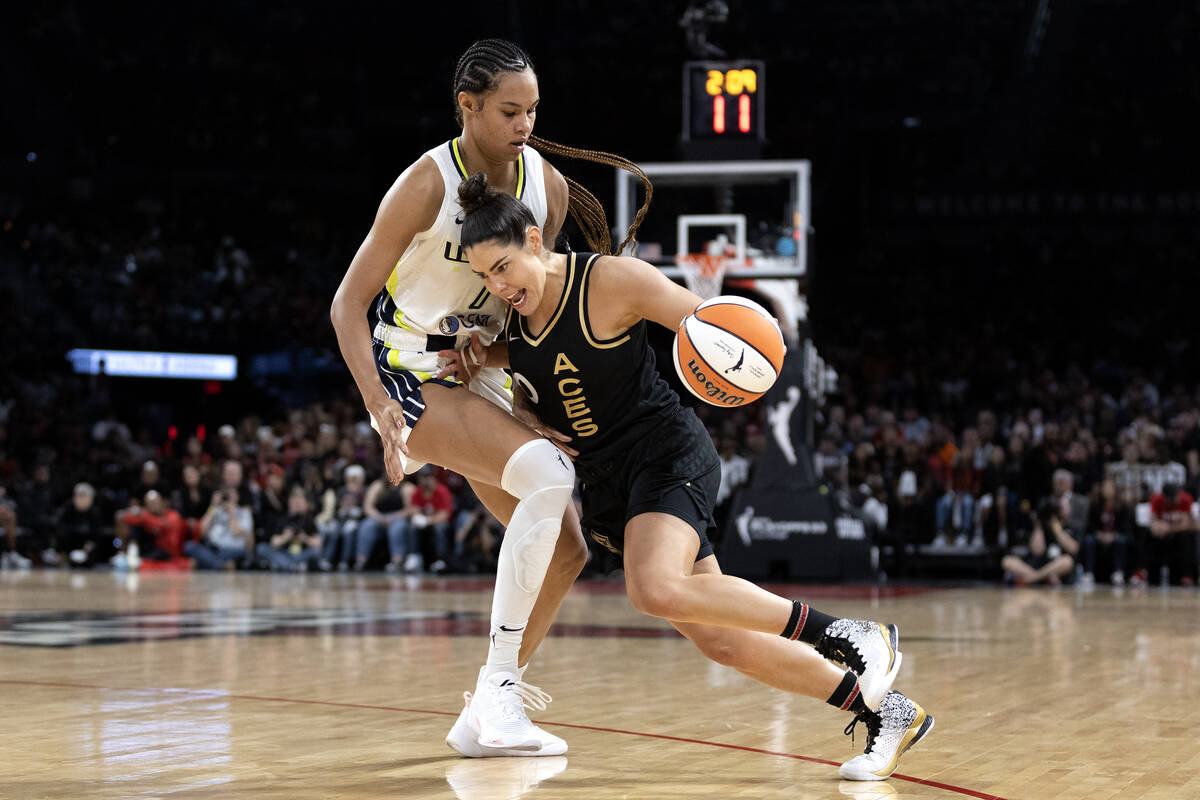 Las Vegas Aces guard Kelsey Plum (10) drives around Dallas Wings forward Satou Sabally (0) duri ...