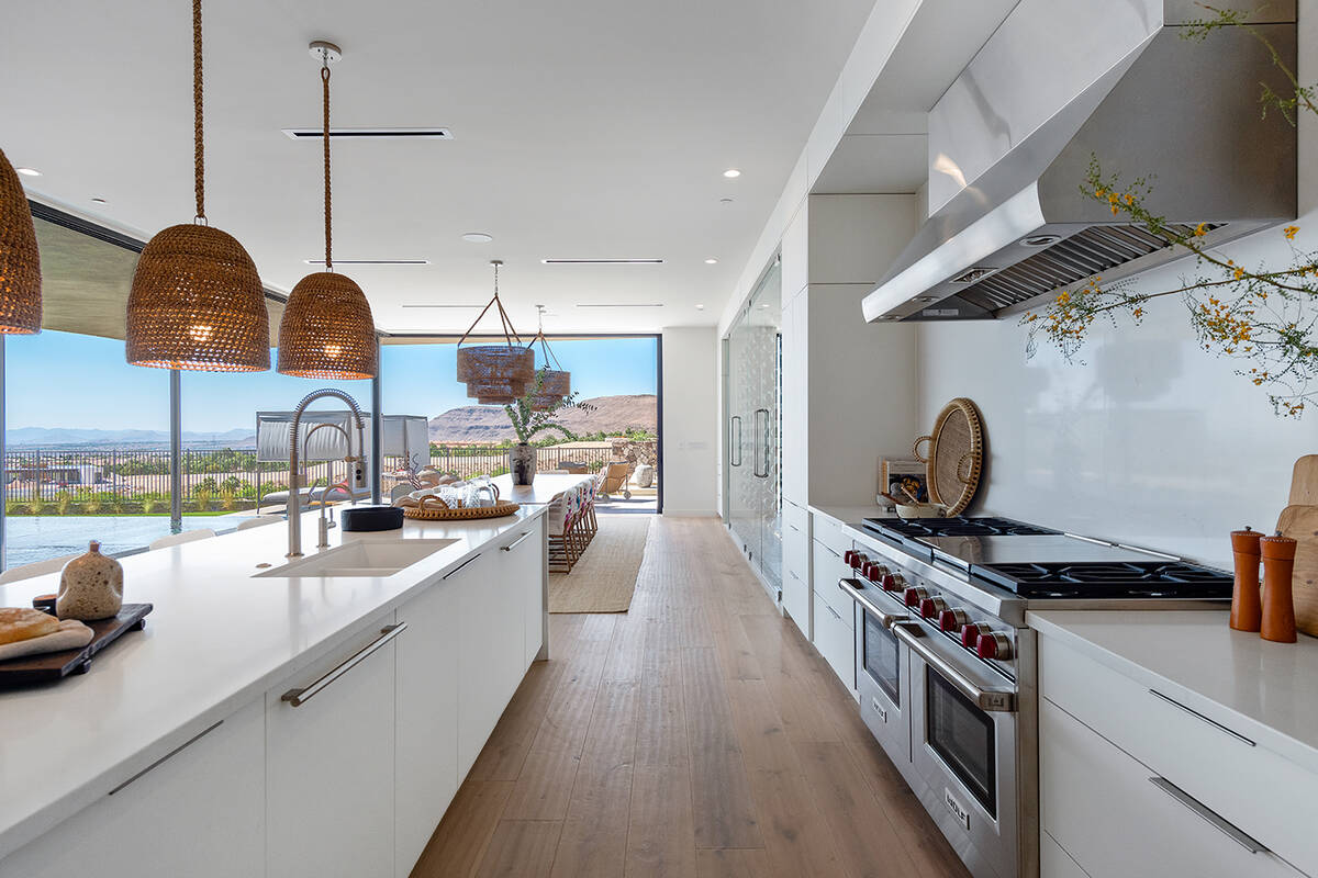 The kitchen features stainless steel appliances, an oversized quartz island with waterfall edge ...
