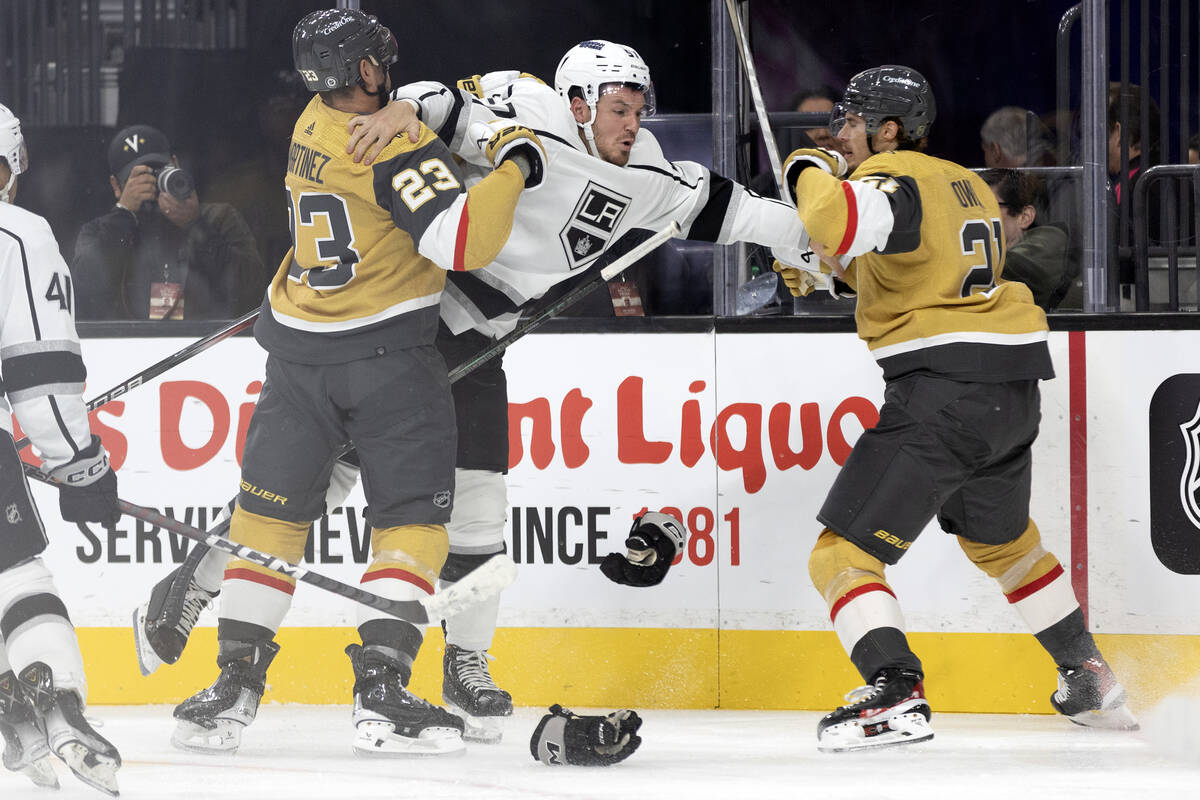 Golden Knights defenseman Alec Martinez (23) holds back Kings right wing Hayden Hodgson (57) wh ...