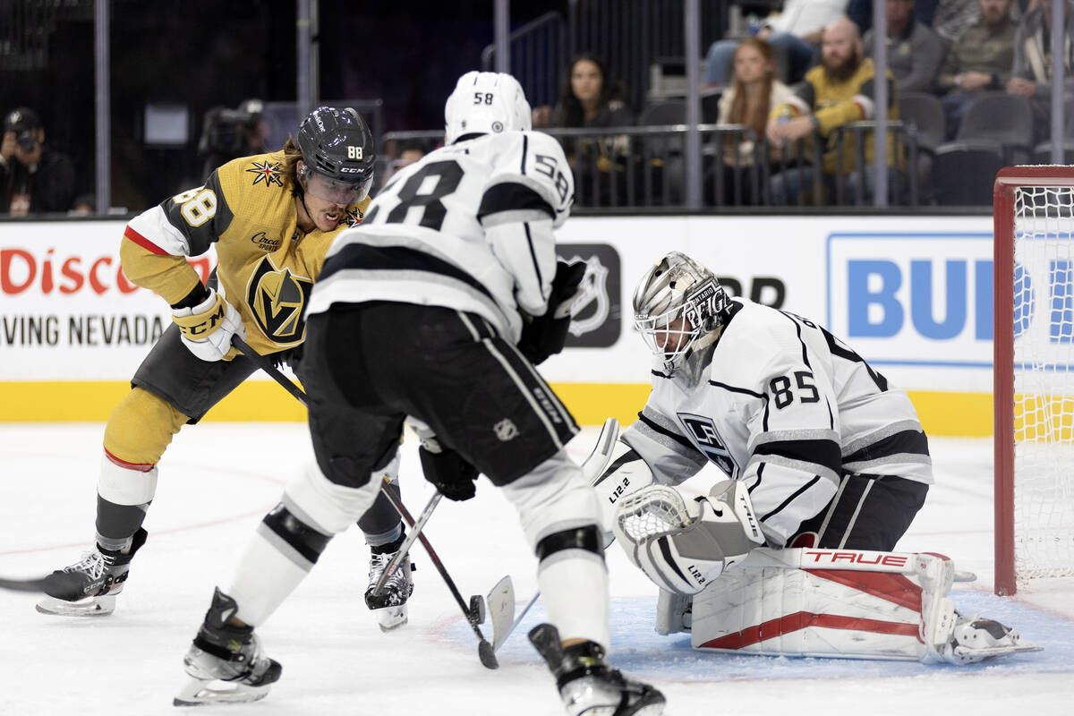 Golden Knights forward Maxime Comtois (88) battles at the net with Kings defenseman Coyle Krygi ...