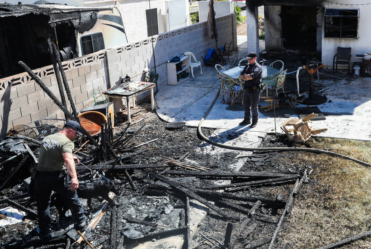 Henderson police and firefighters investigate the perimeters of a demolished home in the afterm ...