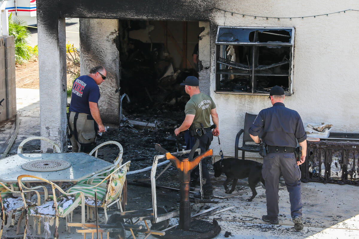 Henderson police and firefighters investigate the inside of a home demolished by a fire, which ...