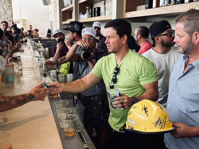 Actor and entrepreneur Mark Wahlberg is shown pouring shots of his Flecha Azul tequila at KAOS ...