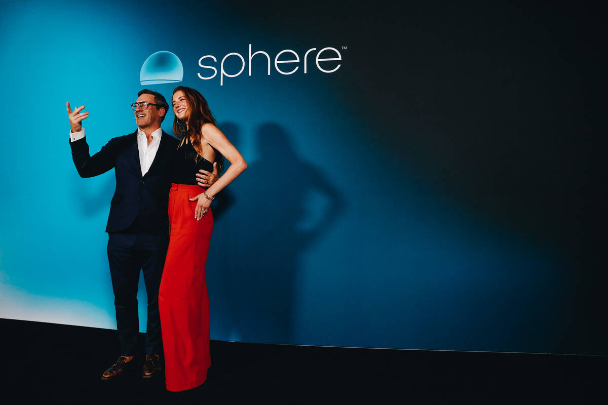 Actor Jon Hamm, left, and his wife, Anna Osceola, pose for photographs outside of the Sphere du ...