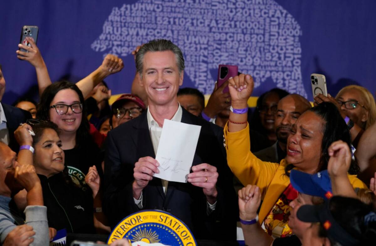 California Gov. Gavin Newsom signs the fast food bill surrounded buy fast food workers at the S ...