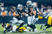 Raiders quarterback Jimmy Garoppolo (10) looks for a receiver after escaping a sack attempt by ...