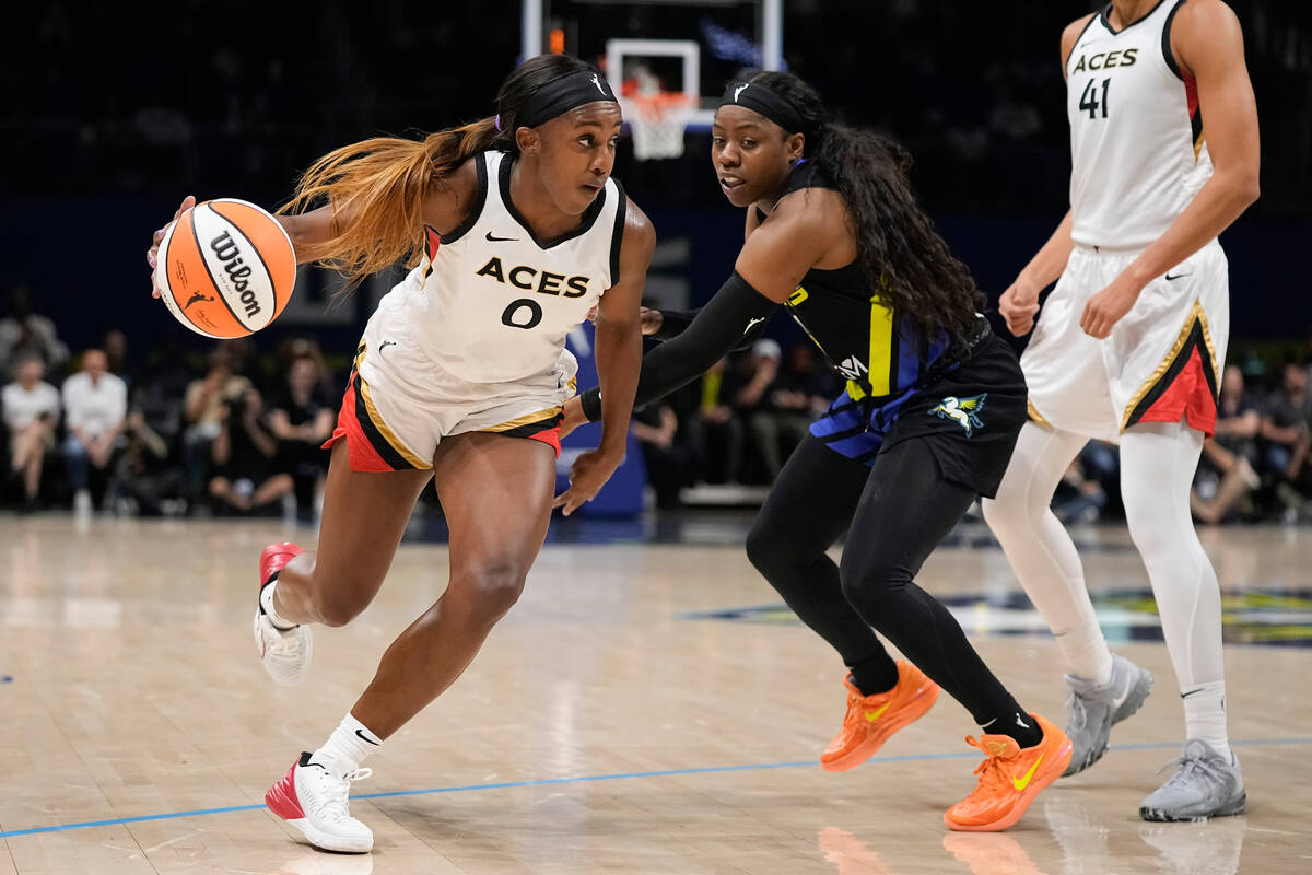 Las Vegas Aces guard Jackie Young (0) drives with the ball past Dallas Wings guard Arike Ogunbo ...
