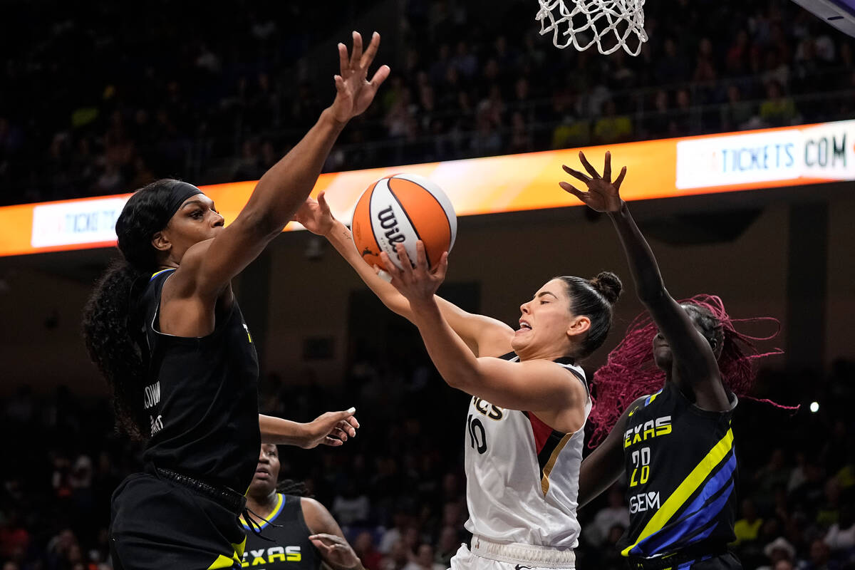 Las Vegas Aces guard Kelsey Plum (10) attempts to pass the ball as Dallas Wings centers Teaira ...