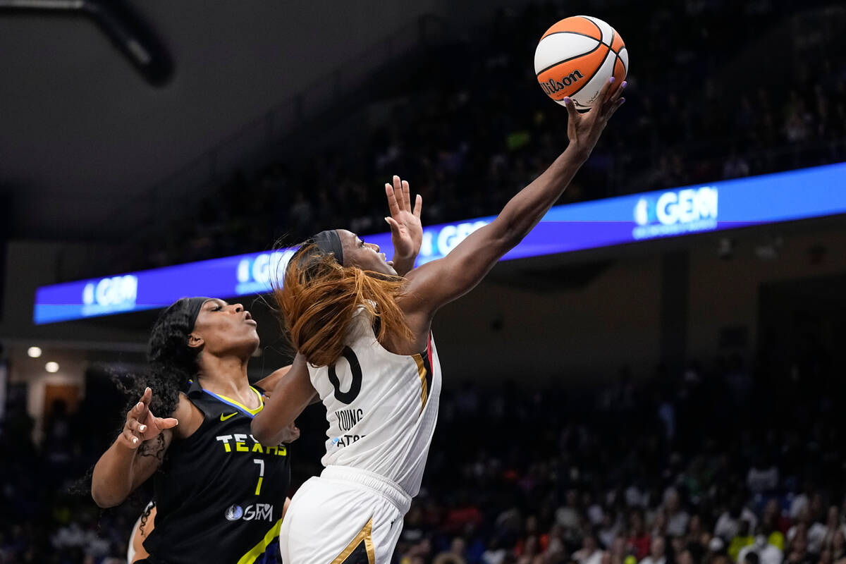 Las Vegas Aces guard Jackie Young (0) makes a move to the basket in front of Dallas Wings cente ...