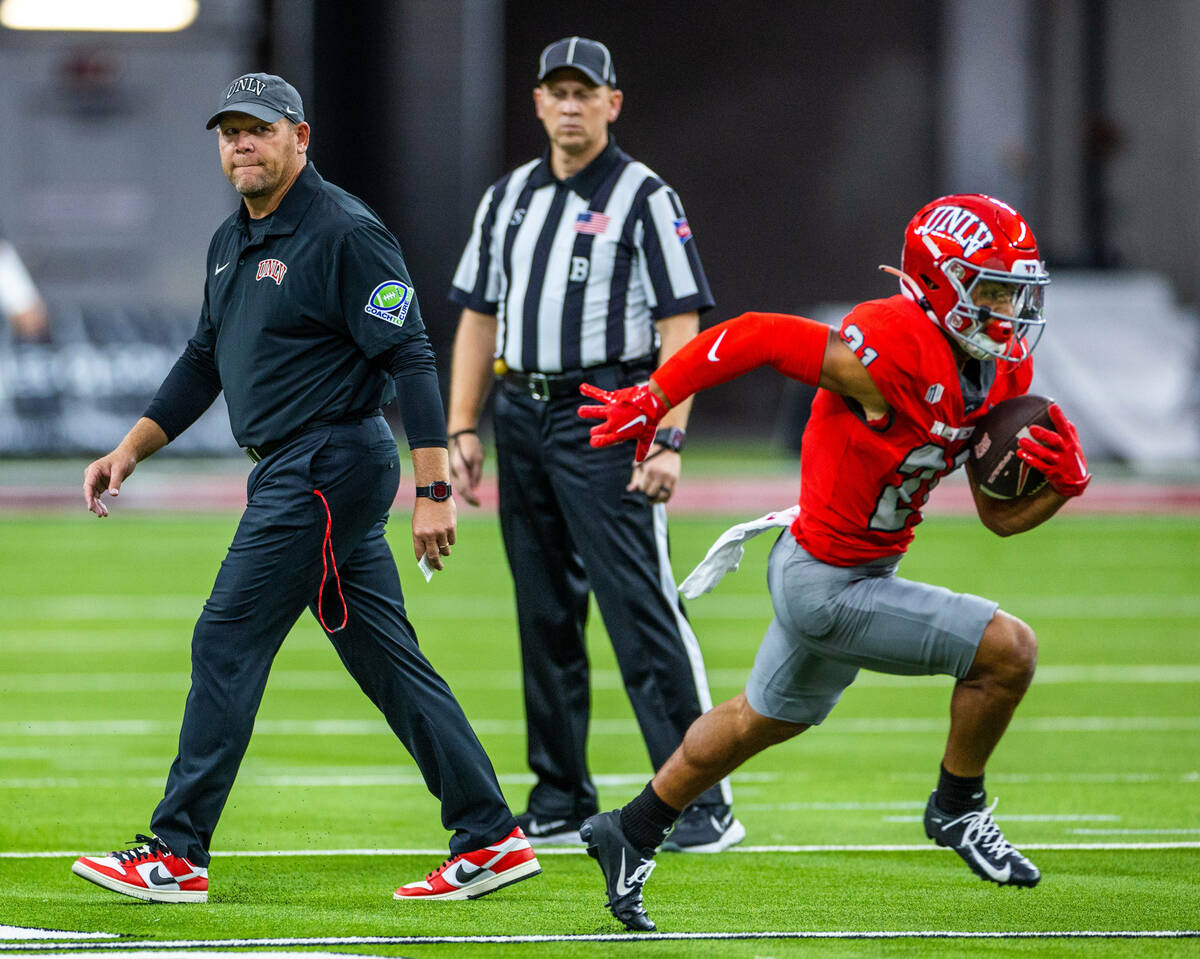 UNLV Head Coach Barry Odom looks to wide receiver Jacob De Jesus (21) as he runs back a punt in ...