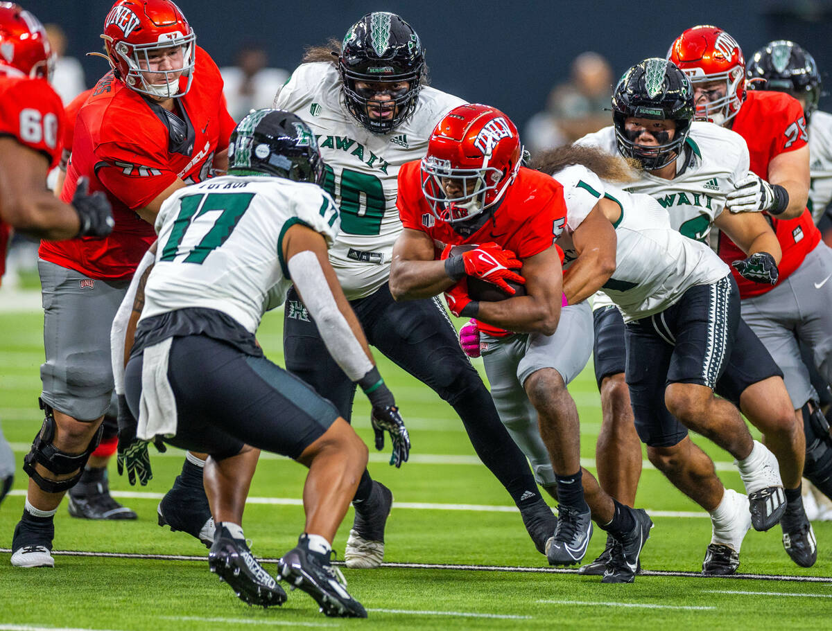 UNLV running back Vincent Davis Jr. (5) battles through the line for more yards facing Hawaii l ...