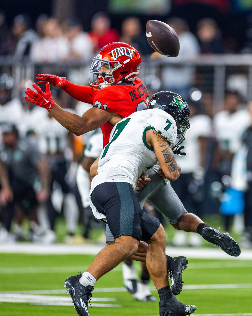 UNLV wide receiver Jacob De Jesus (21) is hit hard by Hawaii defensive back Meki Pei (7) on a r ...