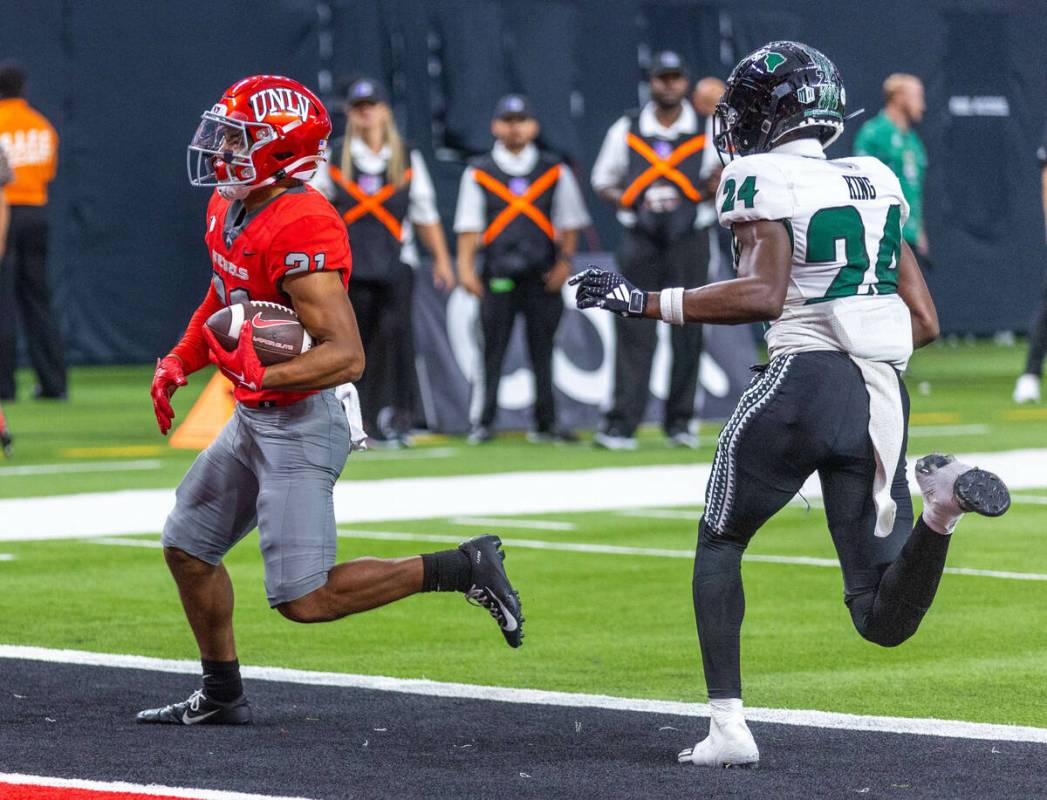 UNLV wide receiver Jacob De Jesus (21) scores on a touchdown pass over Hawaii defensive back De ...