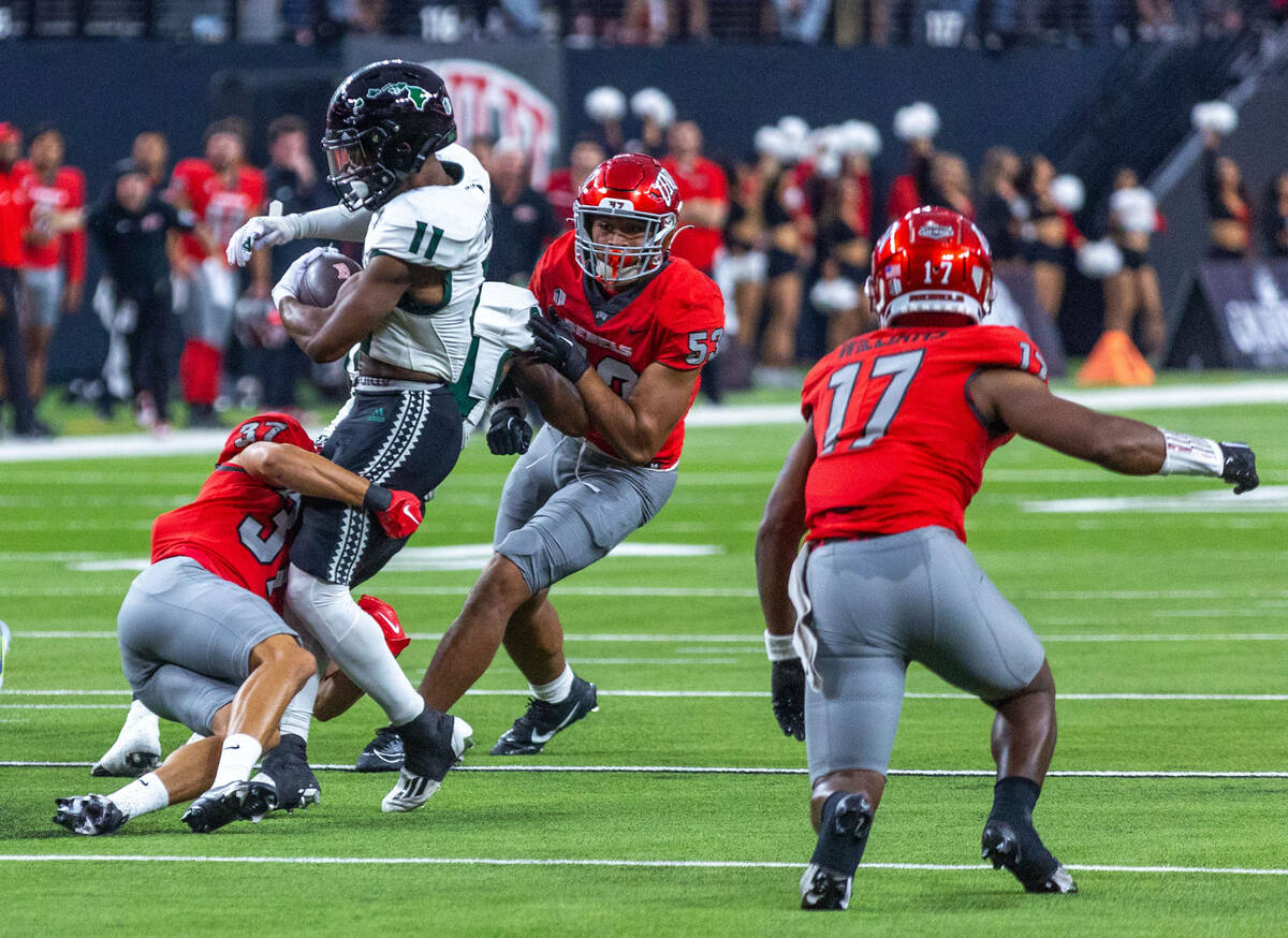 Hawaii running back Jordan Johnson (11) is stopped by UNLV defensive back Davone Walden Jr. (37 ...