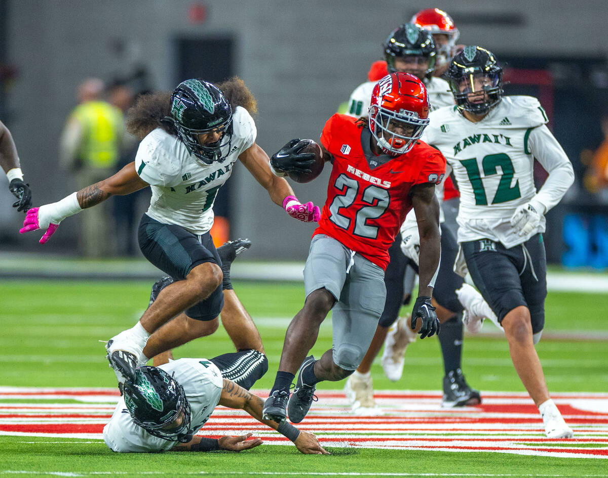 UNLV running back Jai'Den Thomas (22) breaks for the end zone chased by Hawaii defensive back P ...
