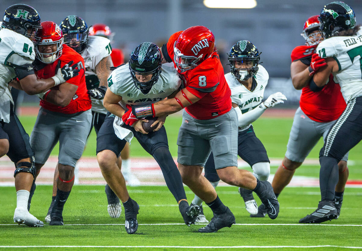 Hawaii quarterback Brayden Schager (13) is sacked by UNLV defensive lineman Darius Johnson (8) ...