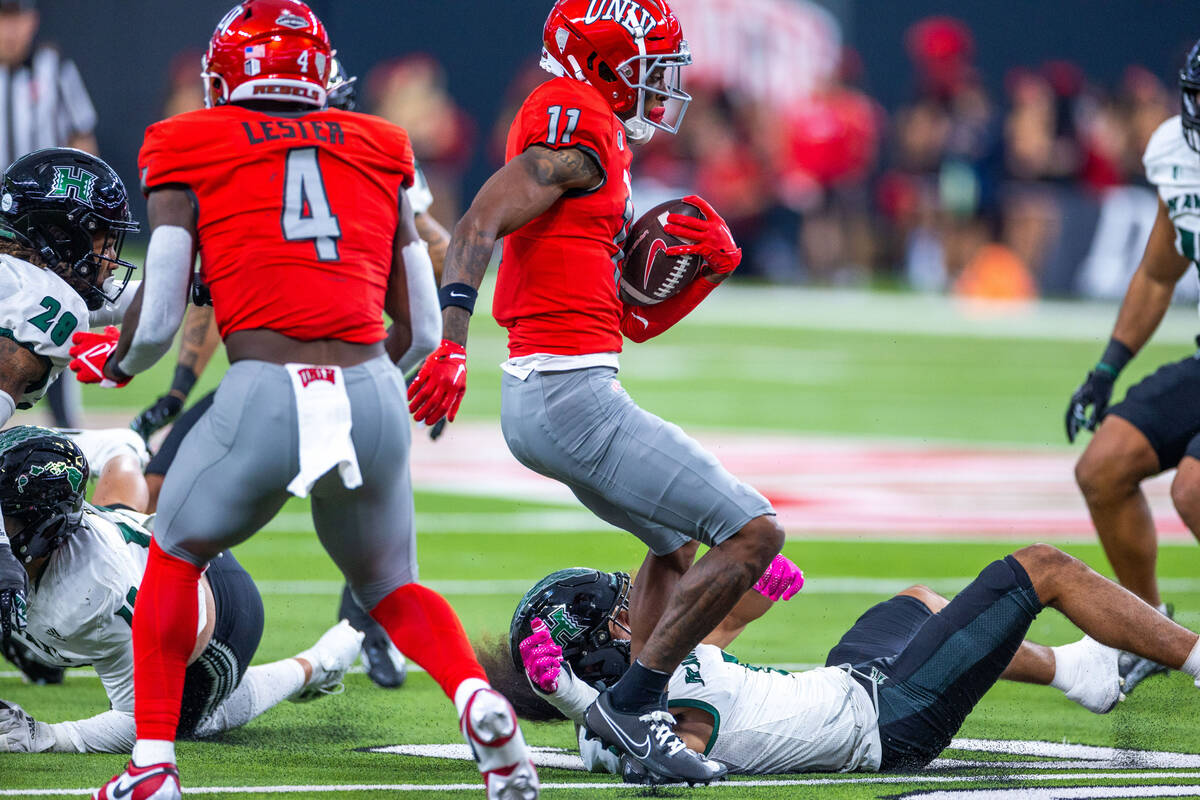 UNLV wide receiver Ricky White (11) moves past Hawaii defensive back Peter Manuma (1) on the gr ...