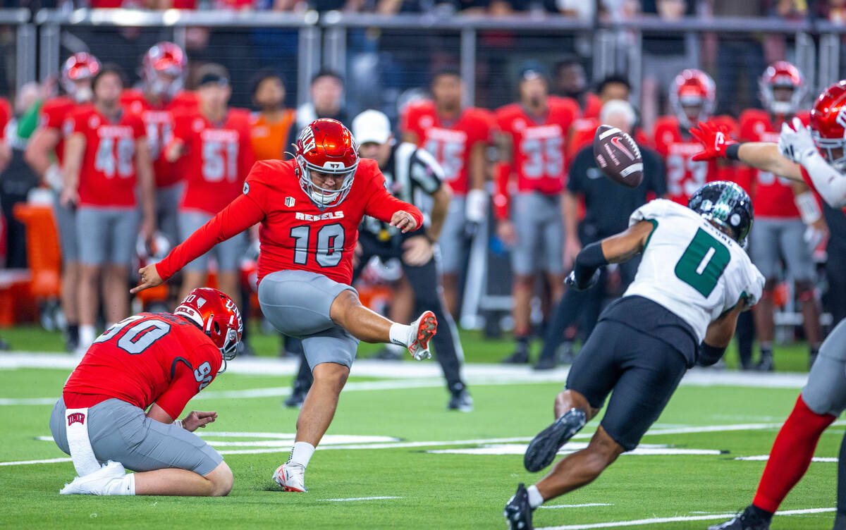UNLV place kicker Jose Pizano (18) secures another extra point past Hawaii defensive back Cam S ...