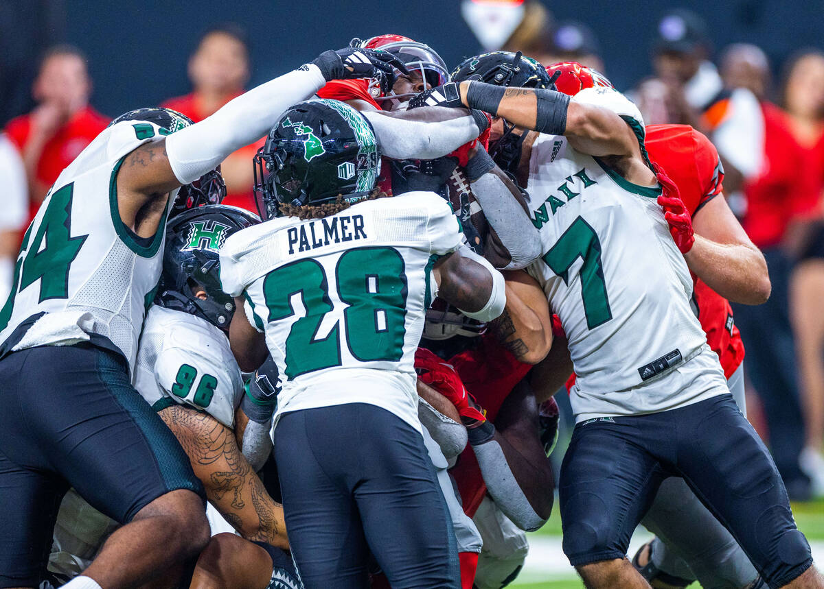 UNLV running back Donavyn Lester (4) battles towards the end zone with Hawaii defensive back El ...