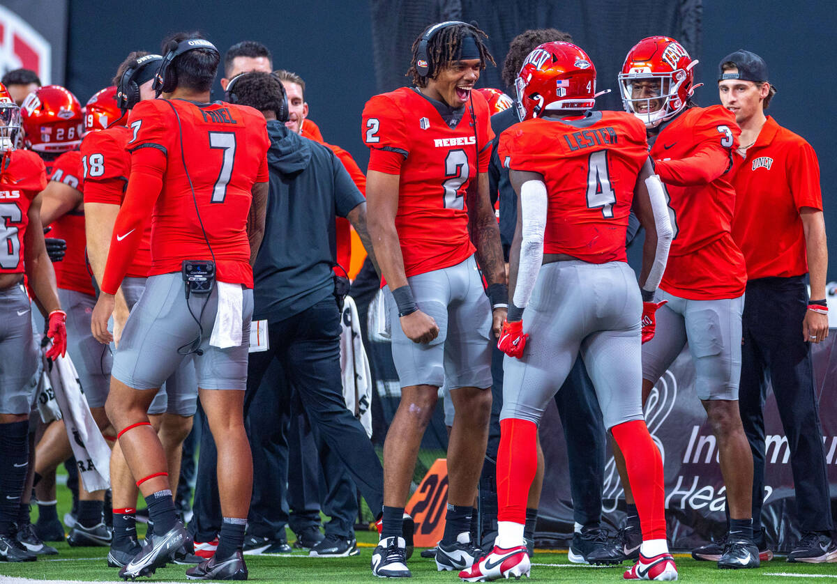 UNLV quarterback Doug Brumfield (2) celebrates a score by running back Donavyn Lester (4) again ...