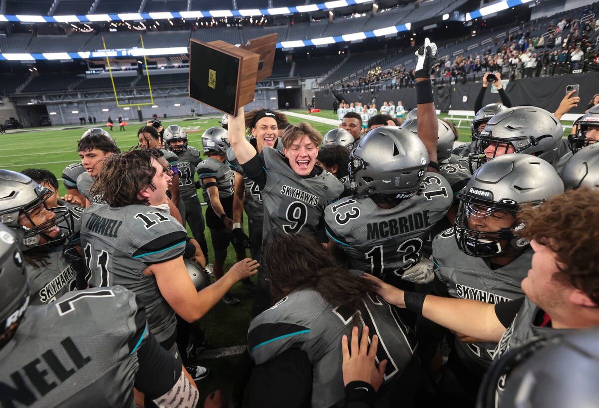 Silverado's Blake Relyea (9) raises the trophy while celebrating with teammates after defeating ...