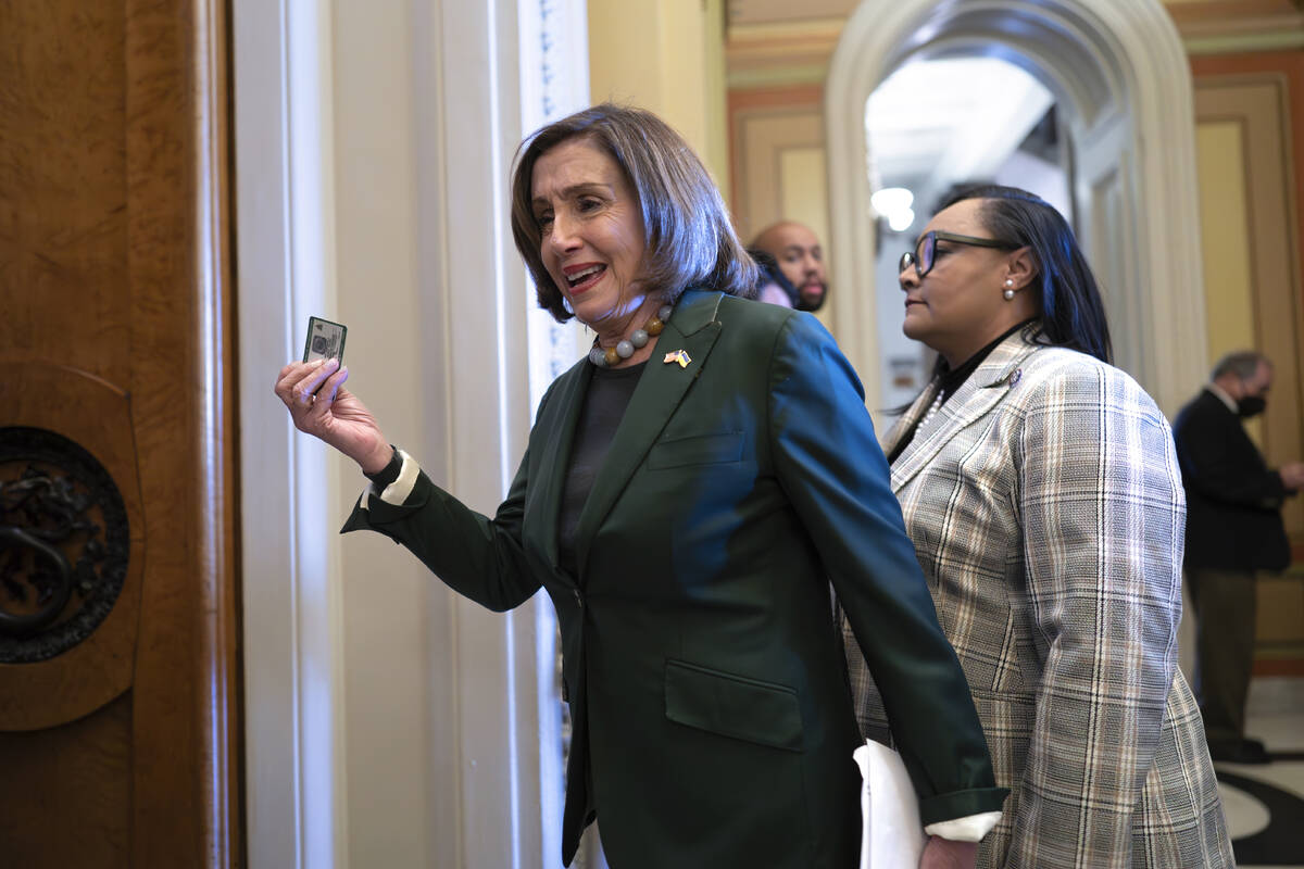 Former House Speaker Nancy Pelosi, D-Calif., displays her voting card as she arrives at the cha ...