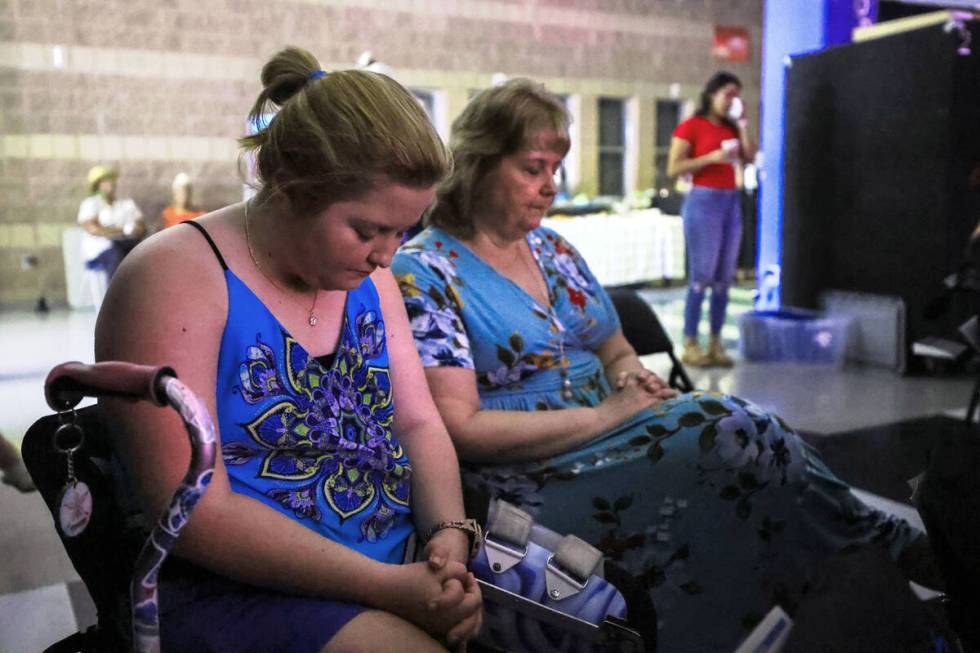 Emma and her mother pray at a service at Walk Church at Schofield Middle School. (Rachel Aston/ ...