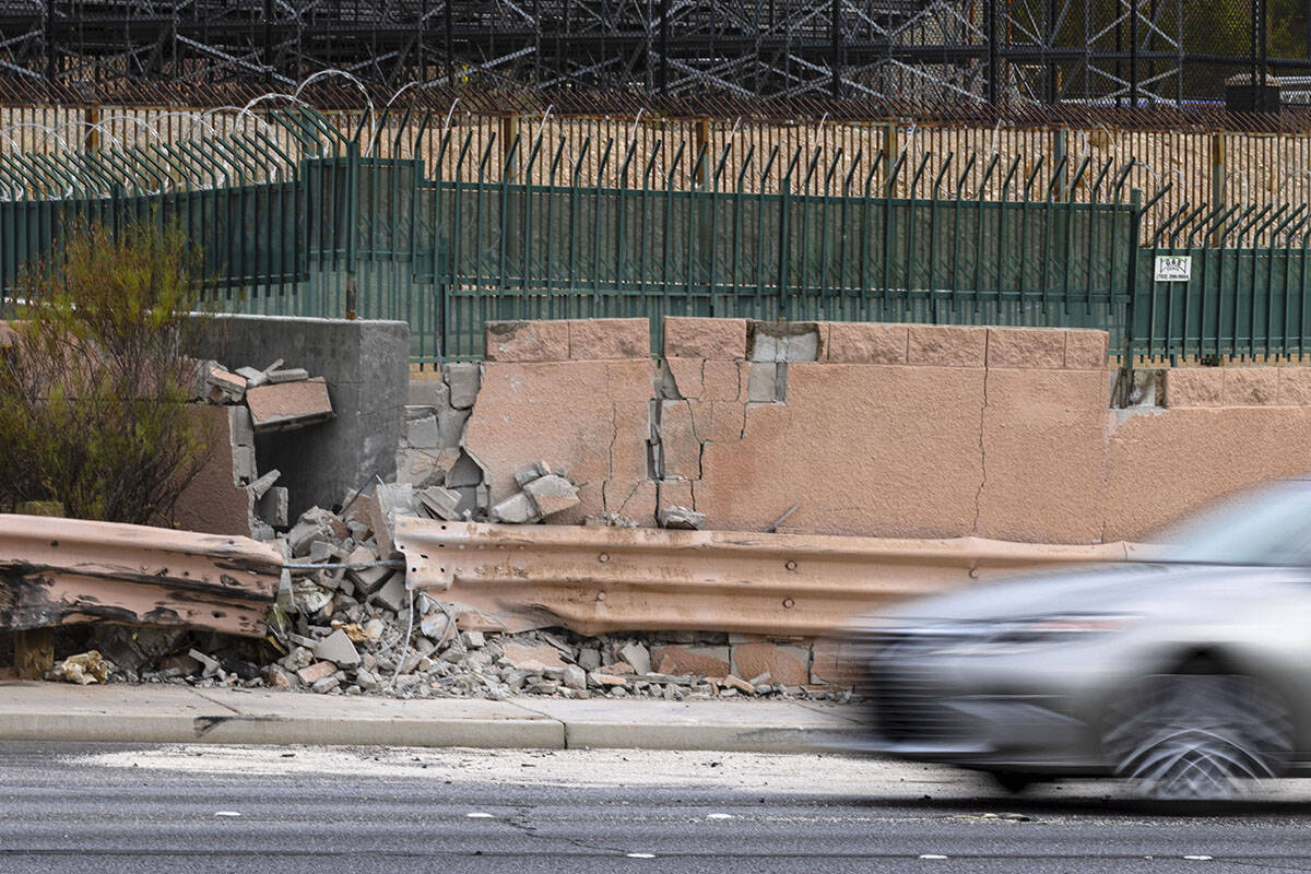 A motorist drives past a damaged wall after a fatal crash near the intersection of Charleston ...