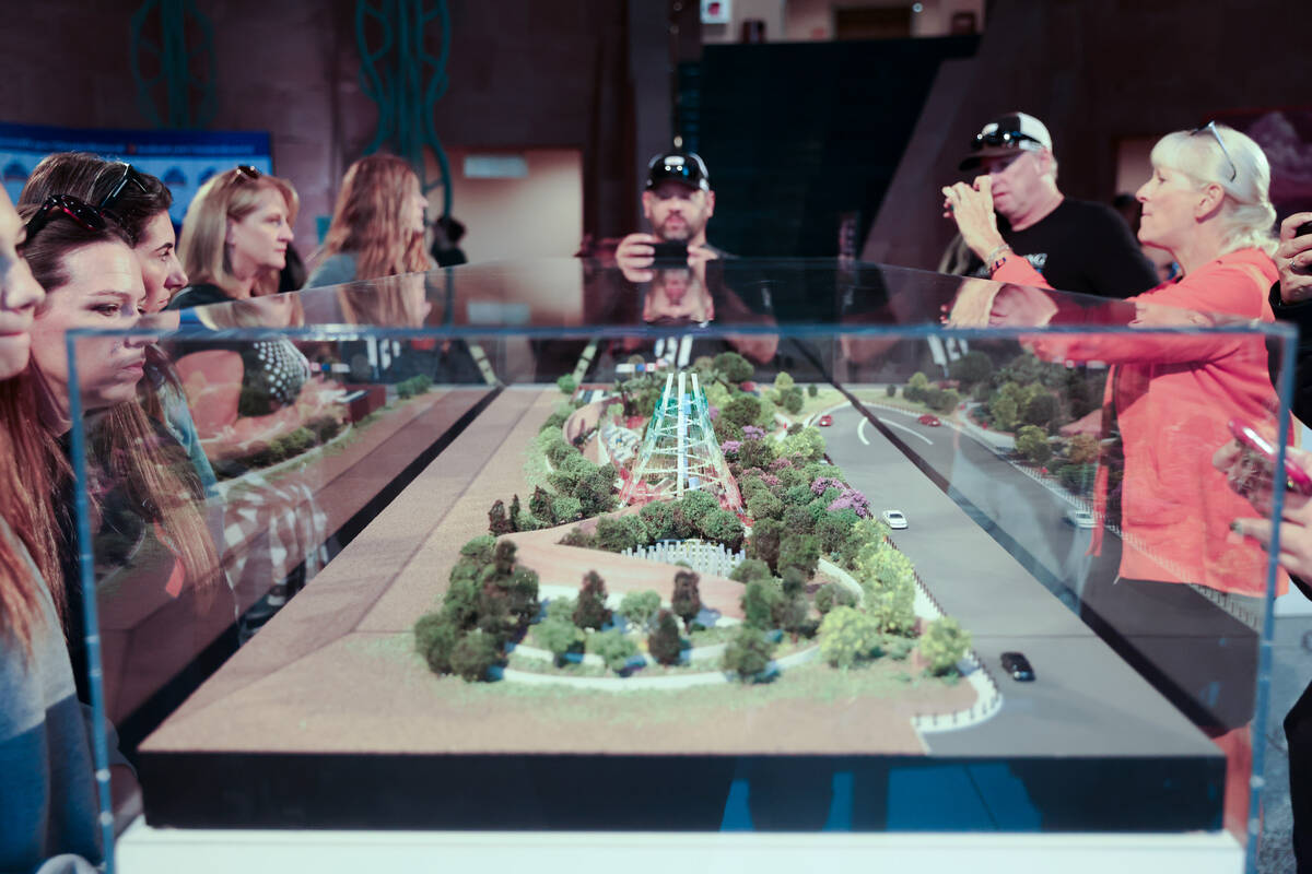 People gather around a diorama of the future memorial that will be on the festival grounds wher ...